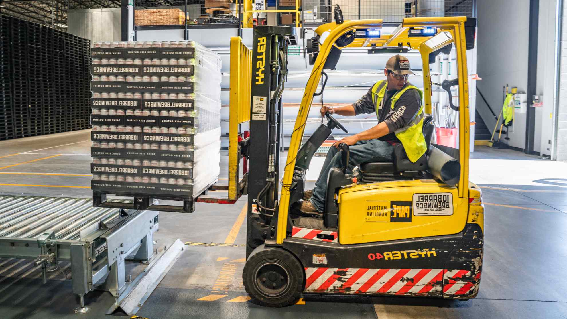 Person driving forklift ina a warehouse.